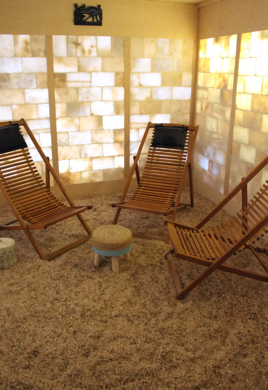 The Centre's salt sanctuary — wooden sling loungers on a floor of salt crystal, with a back-lit salt-brick wall.